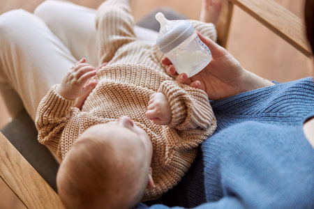 Mother holding her newborn baby and milk bottle