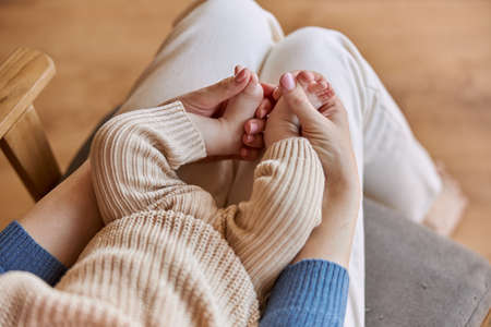 Mother touching small legs of her newborn babyの写真素材