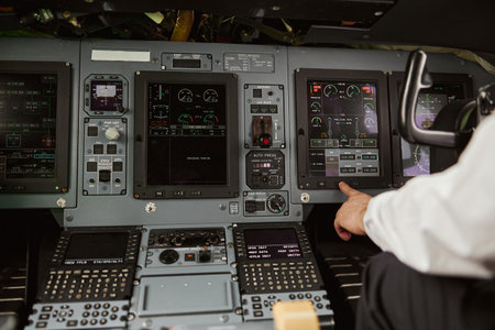 Male pilot pushing button on passenger airplaneの写真素材