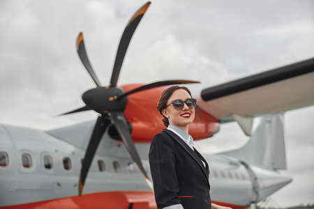 Young stewardess on background of airplane jetの写真素材