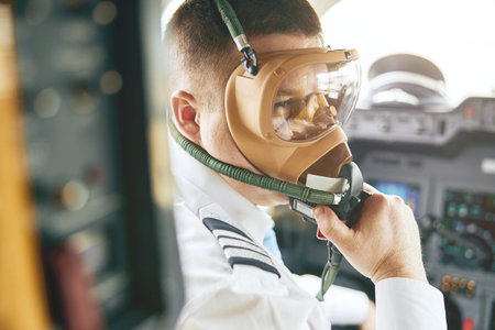 Male pilot take off air mask in cockpit of plane