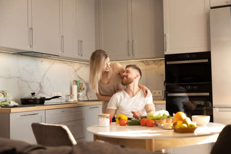 Smiling european couple on kitchen at homeの写真素材