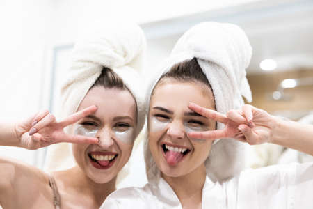 Girls sticking out tongues and show victory signsの写真素材