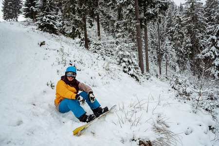 Adventure to winter sport. Snowboarder man hiking at mountain. Looking for powder to freerideの写真素材