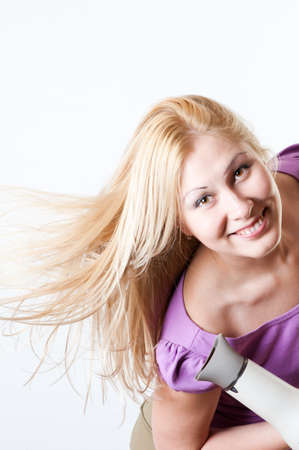 Portrait of a girl with a hairdryerの写真素材