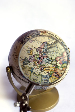 Focusing on Europe on a globe, using a magnifying glass