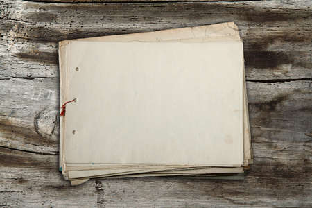 stack of old papers on old wooden backgroundの写真素材