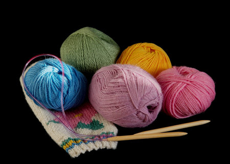 Woolen knit balls and spokes on black backgroundの写真素材