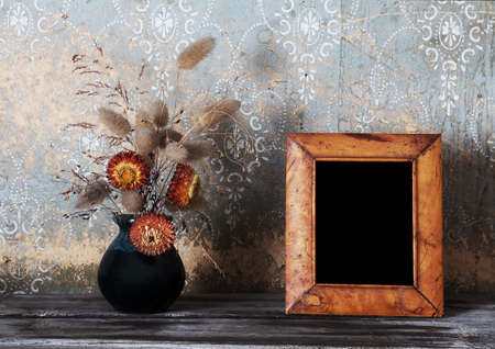 vintage photo-frame and ikebana on old tableの写真素材