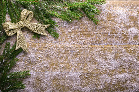 holiday decoration with snow and green branch on wooden frozen table, christmasの写真素材