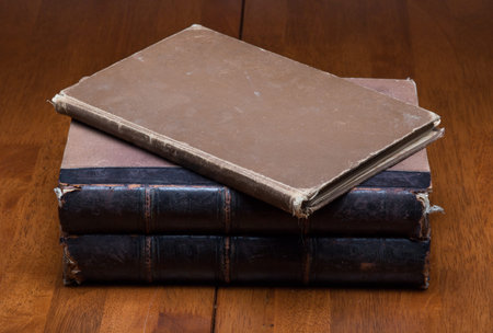 stack of old books on wooden table