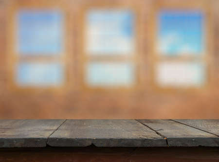 vintage wooden table in old room with big windowsの写真素材