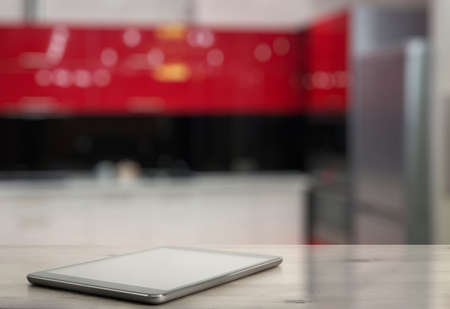 tablet on wooden table in the kitchenの写真素材