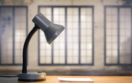 lamp and notebook on table in old room with big windowsの写真素材