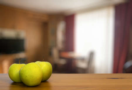 green apples on wooden table in the living roomの写真素材