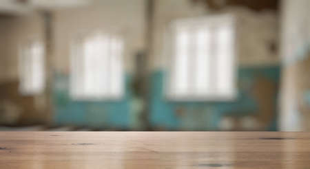 vintage wooden table in old room with big windowsの写真素材