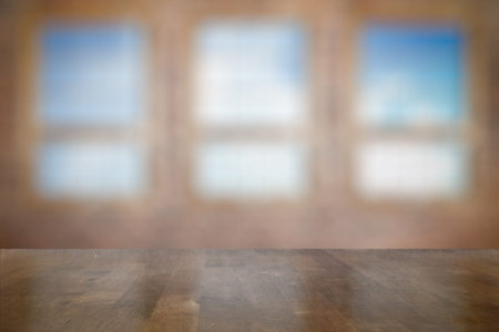 vintage wooden table in old room with big windowsの写真素材