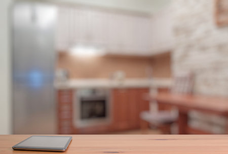 tablet on wooden table in the kitchenの写真素材