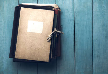 stack of retro folders on old blue wooden backgroundの写真素材