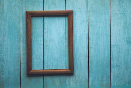 old wooden photo frame on blue wooden wallの写真素材