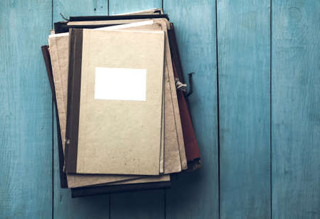 stack of retro folders on old blue wooden backgroundの写真素材
