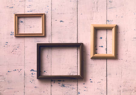 vintage photo frames on old pink wooden wallの写真素材