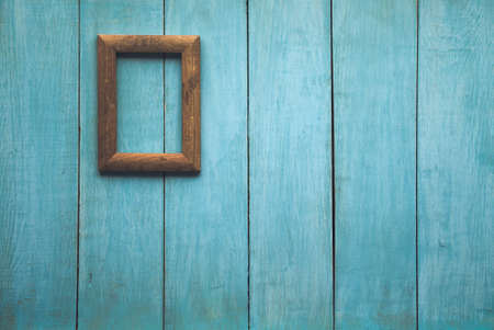old wooden photo frame on blue wooden wallの写真素材