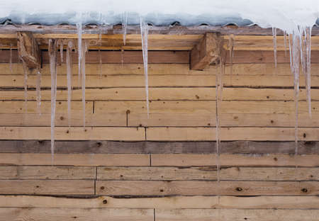 icicles on a wooden wallの写真素材