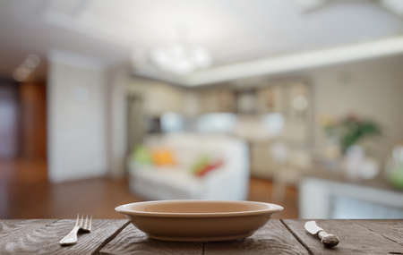 empty plate with fork and knife on wooden table in the living roomの写真素材