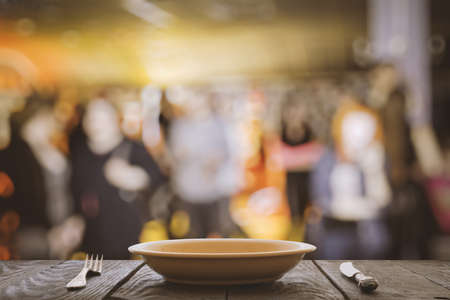 empty plate with fork and knife on wooden table in the restaurantの写真素材