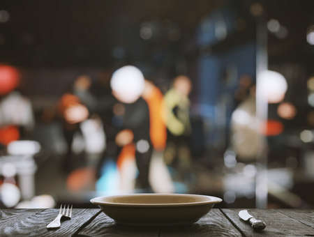 empty plate with fork and knife on wooden table in the restaurantの写真素材