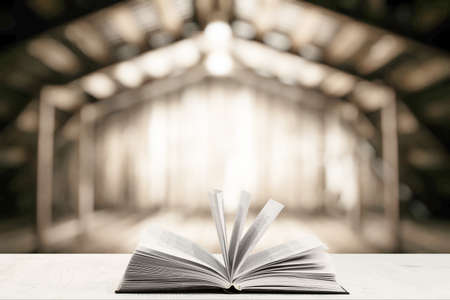 open book on white table in old wooden interior with light bulbの写真素材