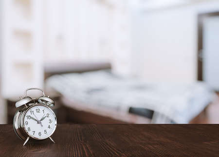 clock on wooden table in the bedroomの写真素材