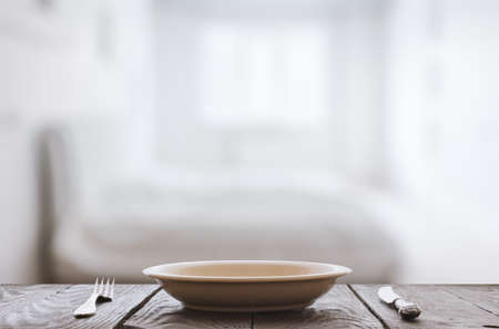 empty plate with fork and knife on wooden table in the bedroomの写真素材