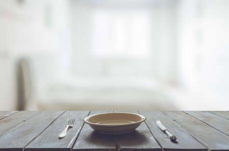 empty plate with fork and knife on old wooden table in the bedroomの写真素材