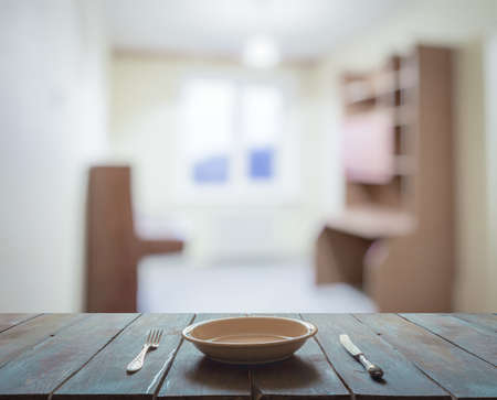 empty plate with fork and knife on wooden table in the living roomの写真素材