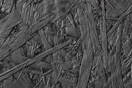 black sawdust, dark wooden background