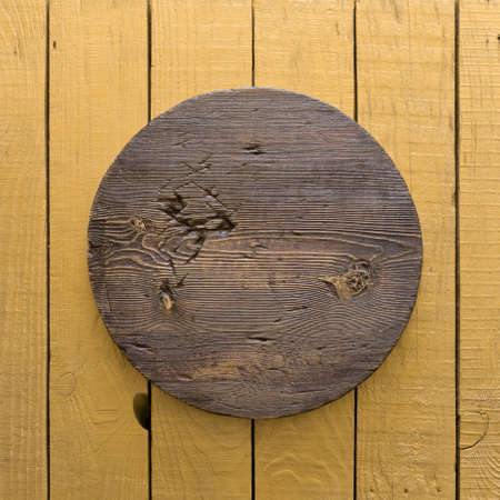 grunge empty round wooden plate on old wooden table, background with copyspaceの写真素材