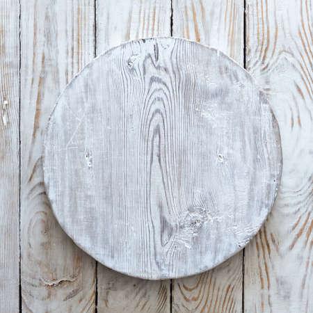 grunge empty round wooden plate on old wooden table, background with copyspaceの写真素材