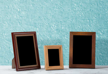 wooden photo frames on table, blue wallの写真素材