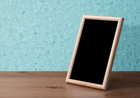 wooden photo frame on table, blue wallの写真素材