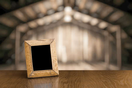 photo frame on old table in old wooden interiorの写真素材
