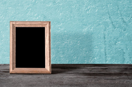 wooden photo frame on table, blue wall