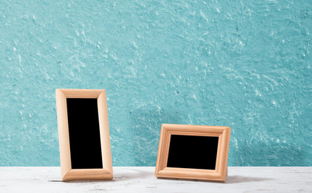 wooden photo frames on table, blue wall