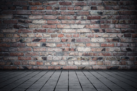 Empty room with bricks wall and tiled floor. Dark background.の写真素材