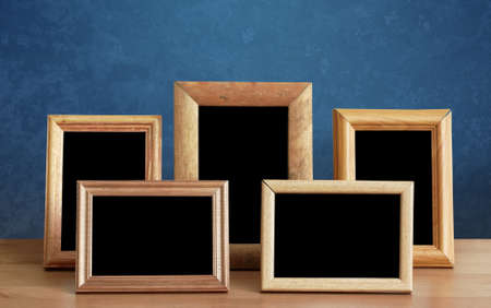 wooden photo frames on table, blue wallの写真素材
