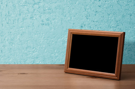 wooden photo frame on table, blue wall