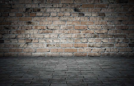 Empty room with bricks wall and tiled floor. Dark background.の写真素材