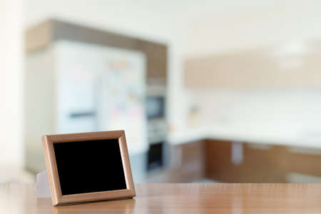photo frame on the wooden table in the kitchenの写真素材