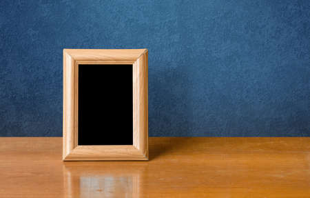 wooden photo frame on table, blue wallの写真素材